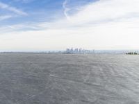 Cityscape Skyline Overlooking Asphalt Plain with Calm Sea