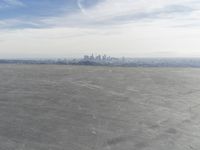 Cityscape Skyline Overlooking Asphalt Plain with Calm Sea
