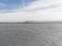 Cityscape Skyline Overlooking Asphalt Plain with Calm Sea