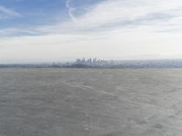 Cityscape Skyline Overlooking Asphalt Plain with Calm Sea
