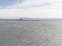 Cityscape Skyline Overlooking Asphalt Plain with Calm Sea