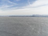 Cityscape Skyline Overlooking Asphalt Plain with Calm Sea