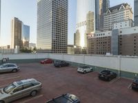 a parking lot with cars parked in it near tall buildings and another building in the background