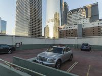 a parking lot with cars parked in it near tall buildings and another building in the background