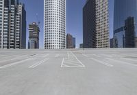 several skyscrapers in an empty parking lot next to each other in a city,