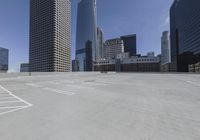 several skyscrapers in an empty parking lot next to each other in a city,