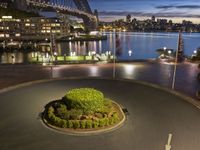 a photo taken at night with a circular clock at the corner and harbour bridge in the background