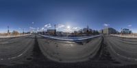 the sun shines through the clouds over the streets in this fish eye lens shot