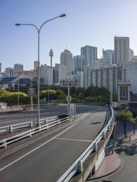 the road looks empty as cars go under a bridge in this view of a city with tall buildings