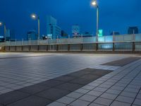 people standing on a subway platform with many buildings in the background at night light in tokyo