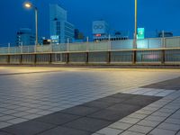 people standing on a subway platform with many buildings in the background at night light in tokyo