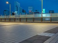 people standing on a subway platform with many buildings in the background at night light in tokyo