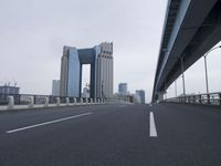 some very tall buildings near some big road bridges and buildings with a highway that is open