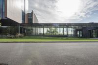 an office building with glass walls and a sun shines on the side of it