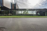 an office building with glass walls and a sun shines on the side of it