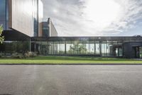 an office building with glass walls and a sun shines on the side of it