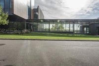 an office building with glass walls and a sun shines on the side of it