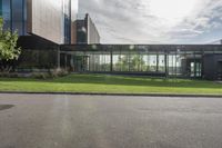 an office building with glass walls and a sun shines on the side of it