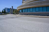 an empty street and a car parked near a building in a city with tall buildings