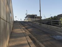 there is a paved sidewalk on the side of this street with the city skyline visible
