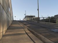 there is a paved sidewalk on the side of this street with the city skyline visible