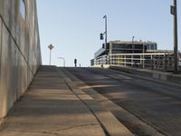 there is a paved sidewalk on the side of this street with the city skyline visible