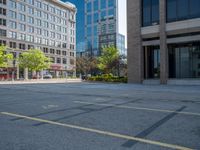 a street with a building near the building in the middle and on the left of which is a parking lot, as shown in this photo