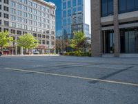 a street with a building near the building in the middle and on the left of which is a parking lot, as shown in this photo