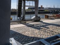 a brick floor that has an open door leading to some buildings and a boat docked in the background