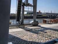 a brick floor that has an open door leading to some buildings and a boat docked in the background