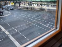 the view out the window on the road from the passenger platform in the city, people walking on the sidewalk, and cars