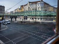 the view out the window on the road from the passenger platform in the city, people walking on the sidewalk, and cars