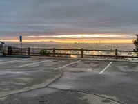 the view over the city from a parking lot at sunset with an umbrella nearby to protect against the sky