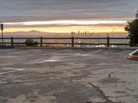 the view over the city from a parking lot at sunset with an umbrella nearby to protect against the sky