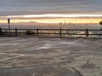 the view over the city from a parking lot at sunset with an umbrella nearby to protect against the sky