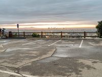 the view over the city from a parking lot at sunset with an umbrella nearby to protect against the sky