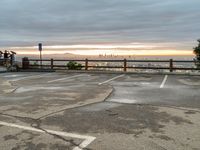 the view over the city from a parking lot at sunset with an umbrella nearby to protect against the sky