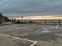 the view over the city from a parking lot at sunset with an umbrella nearby to protect against the sky