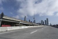 a view of city from inside of a vehicle in a moving blurry picture, including the roof of the vehicle and a sign on the side of the freeway that reads under