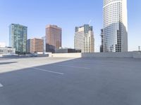 a picture of a parking lot with a bunch of skyscrapers in the background on a sunny day