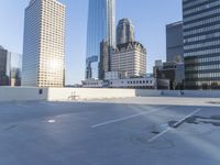 a picture of a parking lot with a bunch of skyscrapers in the background on a sunny day