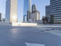 a picture of a parking lot with a bunch of skyscrapers in the background on a sunny day