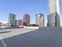 a picture of a parking lot with a bunch of skyscrapers in the background on a sunny day