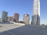 a picture of a parking lot with a bunch of skyscrapers in the background on a sunny day