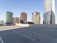 a picture of a parking lot with a bunch of skyscrapers in the background on a sunny day