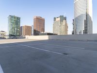 a picture of a parking lot with a bunch of skyscrapers in the background on a sunny day