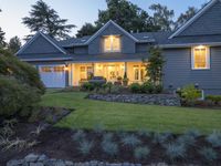 this home has grey walls and green grass on the side with white doors, windows, and shutters