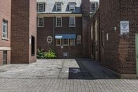 an empty brick alley with a fire hydrant next to it and buildings behind it