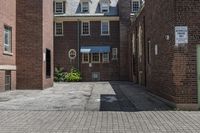 an empty brick alley with a fire hydrant next to it and buildings behind it