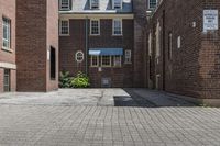 an empty brick alley with a fire hydrant next to it and buildings behind it